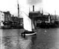 Sailing dinghy between the quays
