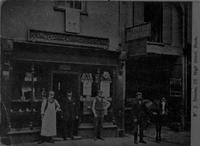 Vintage black and white photo of people standing  outside a store